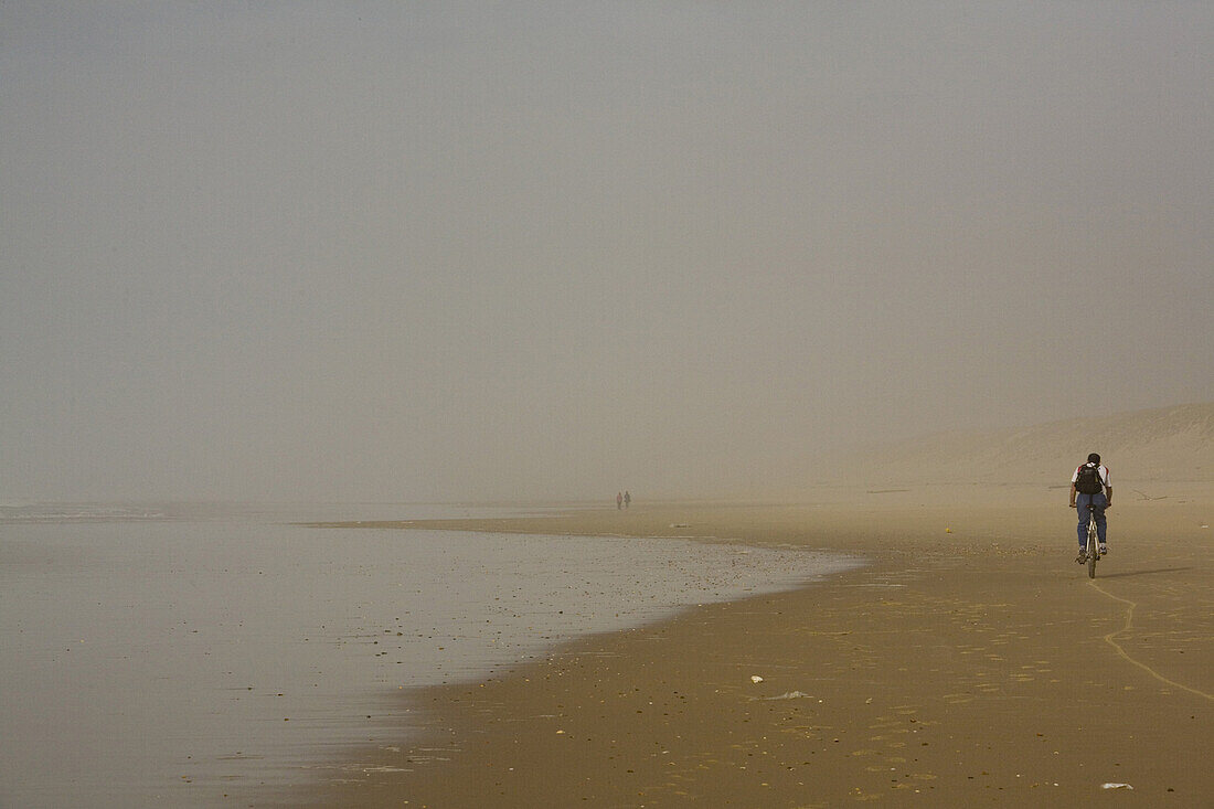 Mountainbiker am Strand im Winter, Bassin d’Arcachon, Lacanau, Gironde, Frankreich, Europa