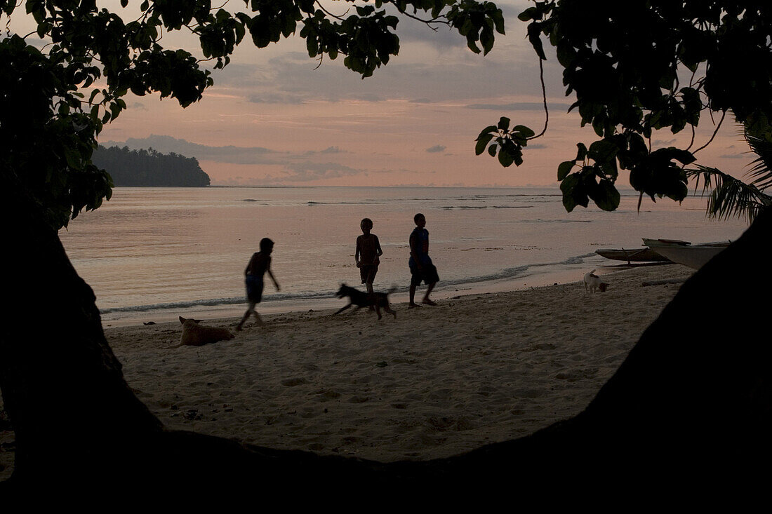 Kinder spielen am Strand von Lagune bei Sonnenuntrgang, Neu Irland, Papua Neuguinea