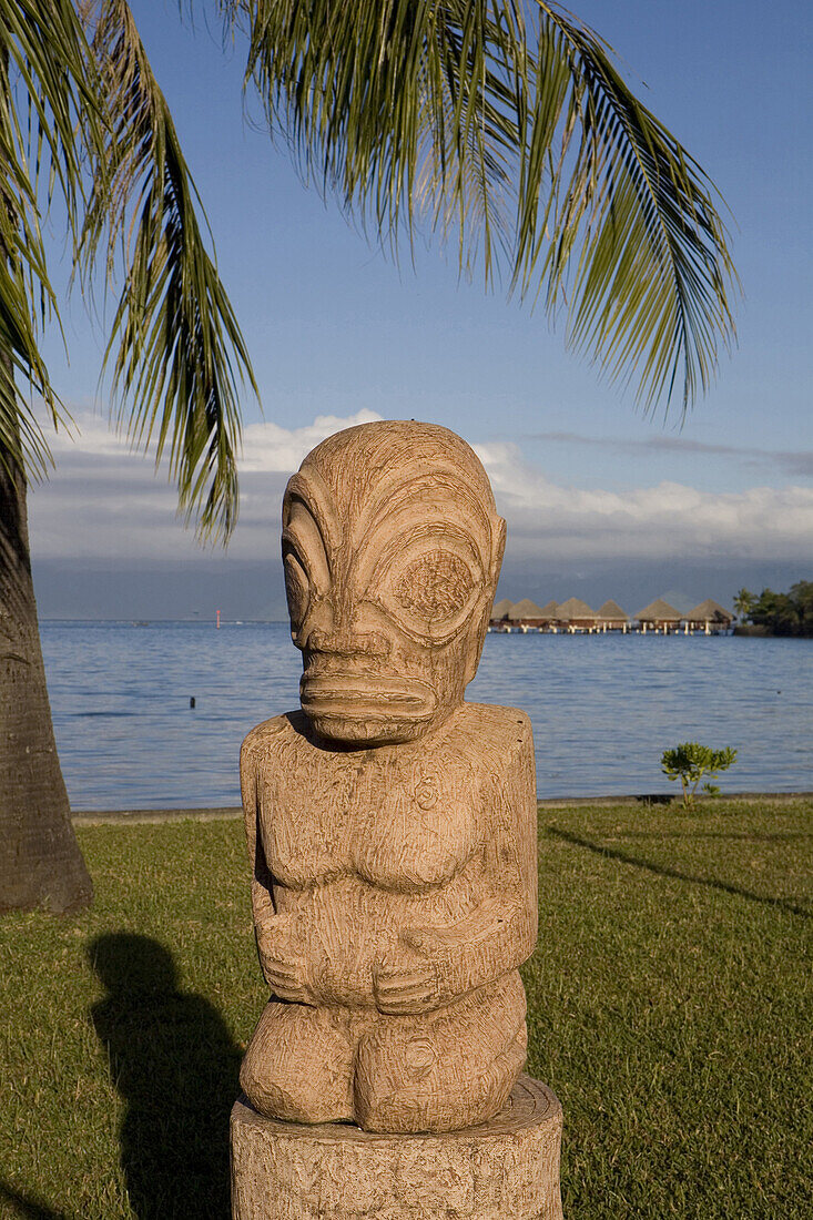 Tiki statue in front of lagoon in the evening light, Papeete, Tahiti, French Polynesia