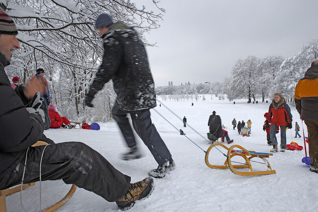 People sledging at English Garden on a winter's day, Munich, Bavaria, Germany