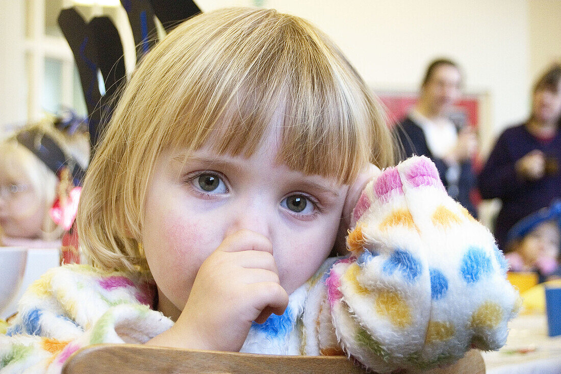 Headshot, 3 year old girl, looking into camera, sucking her thumb
