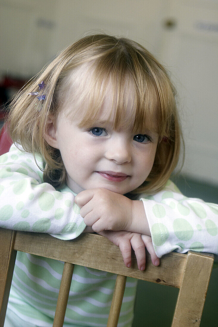 3 year old girl smiling into camera at nursery