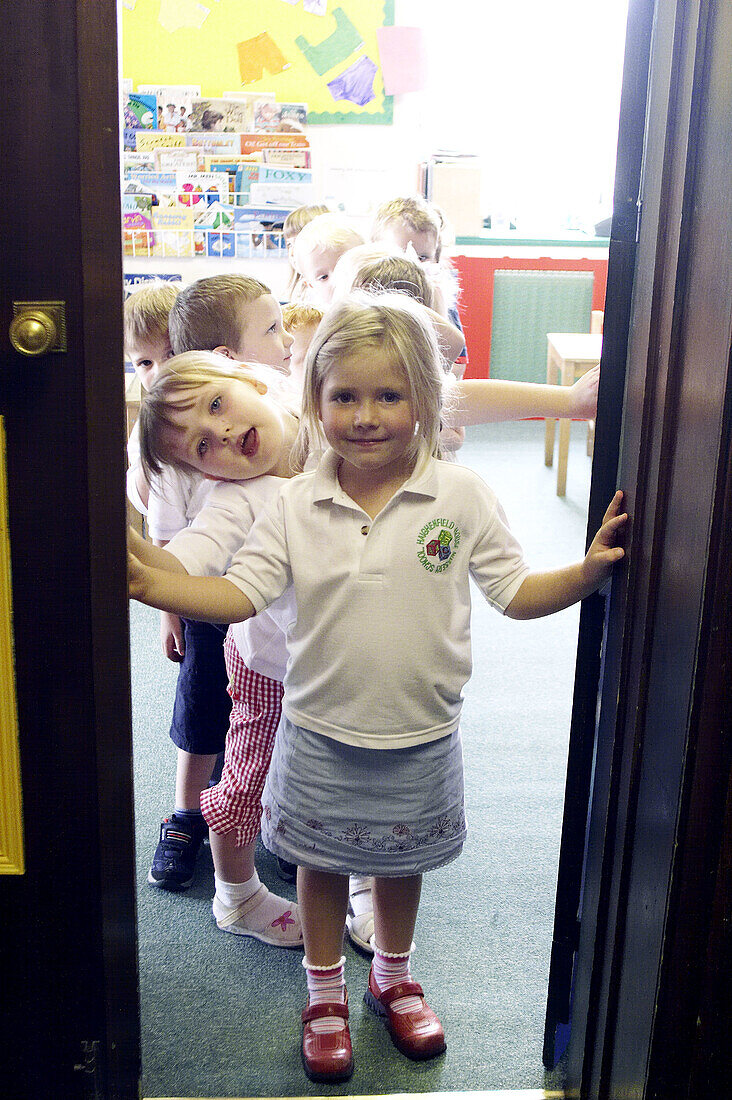 group of 2-4 year old children standing in the doorway of the classroom at nursery