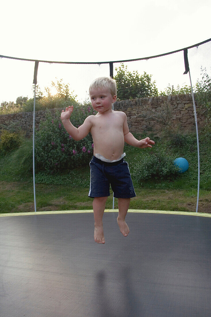 3 year old boys bouncing on a trampoline