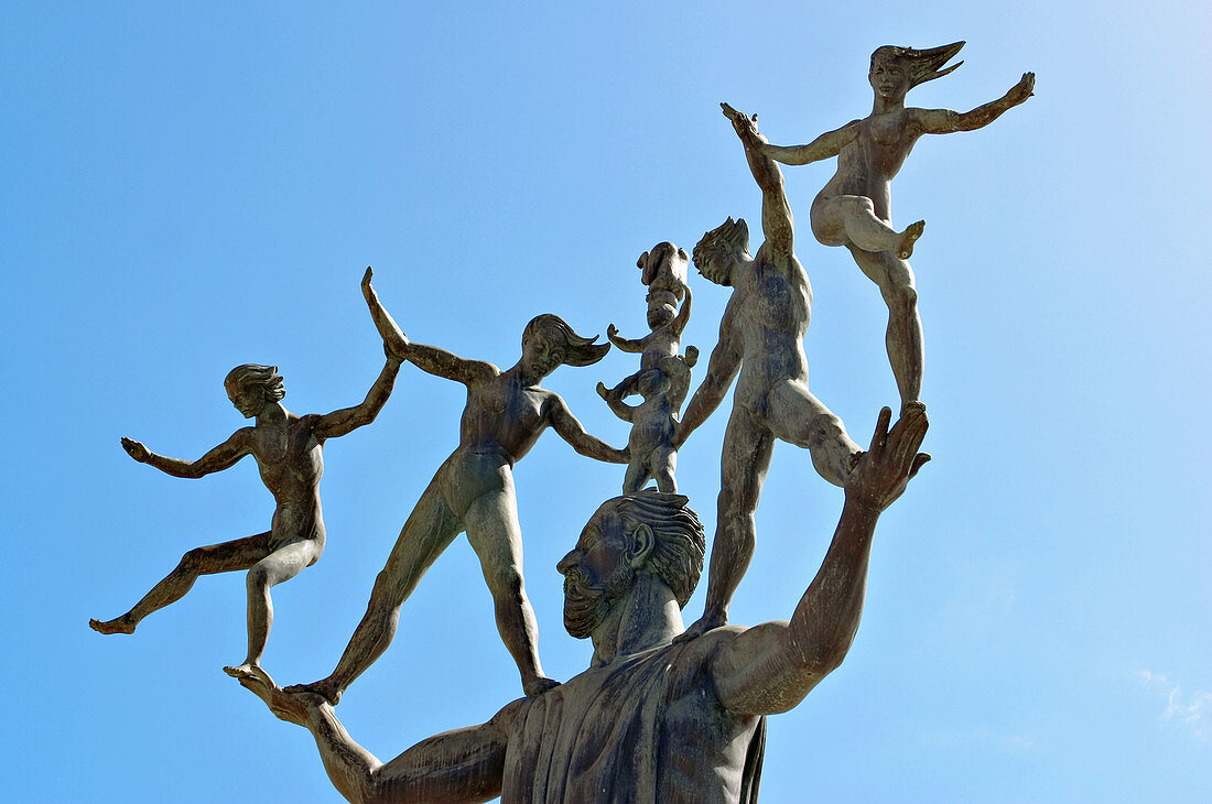 Puerto Rico, San Juan. Sculpture in Plaza del Quinto Centenario, man with people on head and outstretched arms