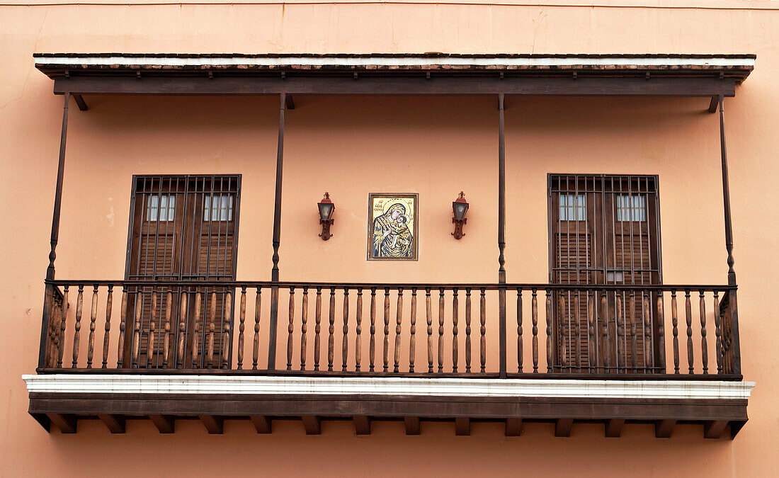 Puerto Rico, San Juan. Wooden second floor balcony, two doors, Virgin Mary and Jesus painting on wall, exterior