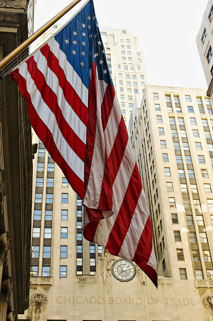USA, Illinois, Chicago. Chicago Board of Trade building and carved name, exterior, USA flag foreground