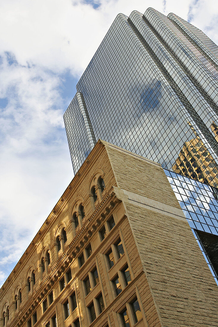 Massachusetts, Boston, Low stone building contrasted with glass and metal highrise, viewed from below