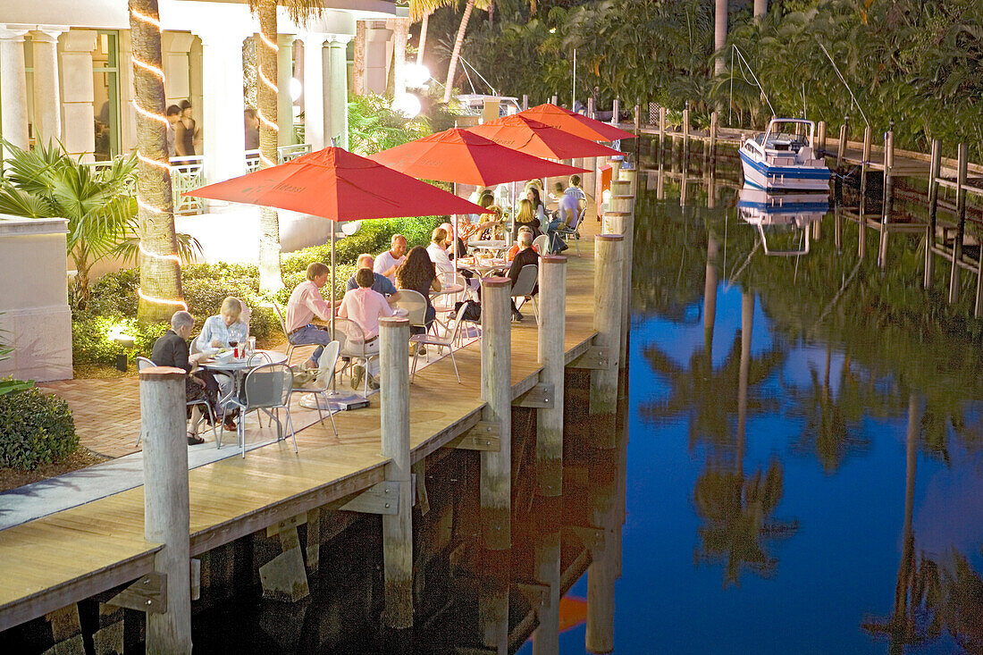 People sitting on the illuminated terrace of the Wild East Grill restaurant in the evening, Fort Lauderdale, Florida, USA