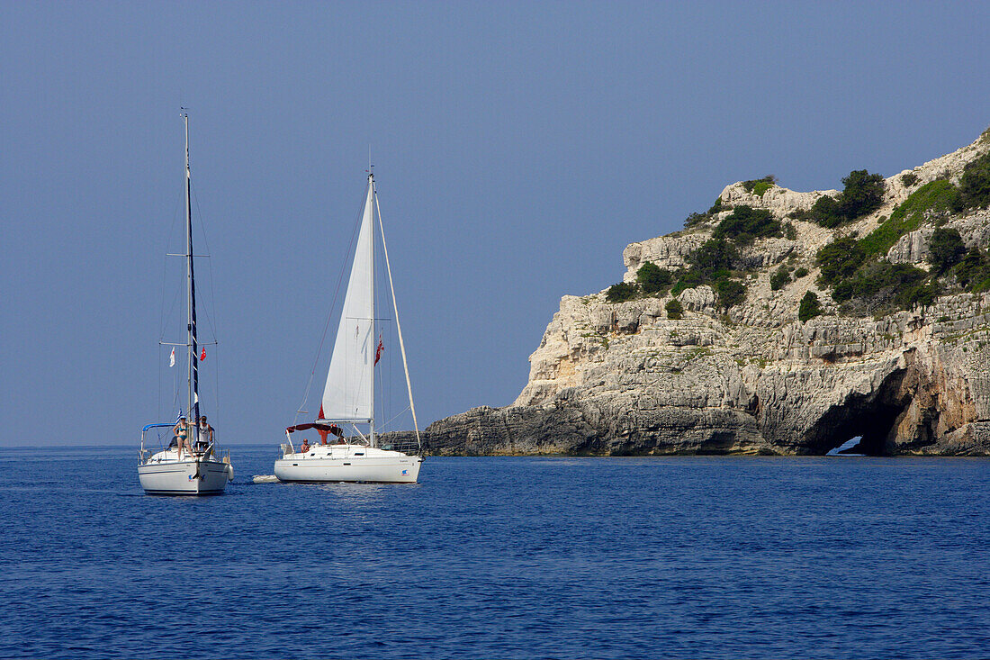 Two sailing boats in front of the caves at west coast, Ionian Islands, Greece