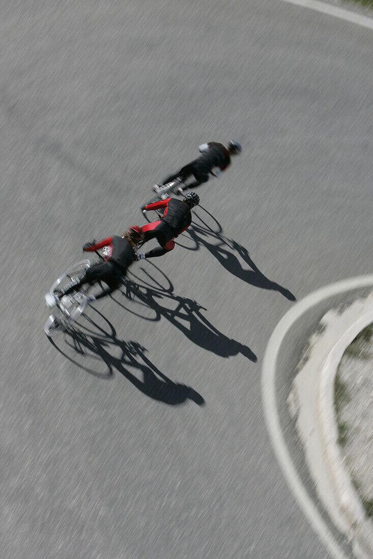 Three cyclists on mountain road, Tre Cime di Lavaredo, Dolomites, Veneto, Italien