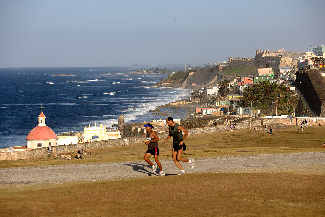 Zwei Jogger im Park des Castillo San Felipe del Morro, Blick über die Nordküste, San Juan, Puerto Rico, Karibik, Amerika