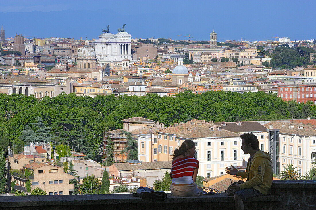 Zwei Menschen sitzen auf einer Mauer, Blick über die Stadt Rom, Italien, Europa