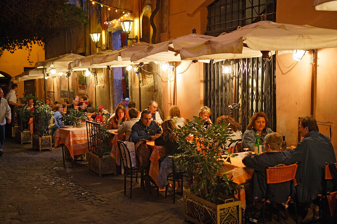 Menschen sitzen abends auf der Terrasse des Restaurants Da Otello, Trastevere, Rom, Italien, Europa