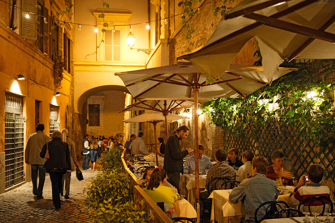 Menschen sitzen abends auf der Terrasse des Restaurants alle Fratte in der Via delle Fratte, Trastevere, Rom, Italien, Europa
