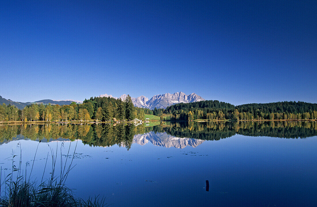 Reflection of Wilder Kaiser range in lake Schwarzsee, Kitzbuhel, Tyrol, Austria