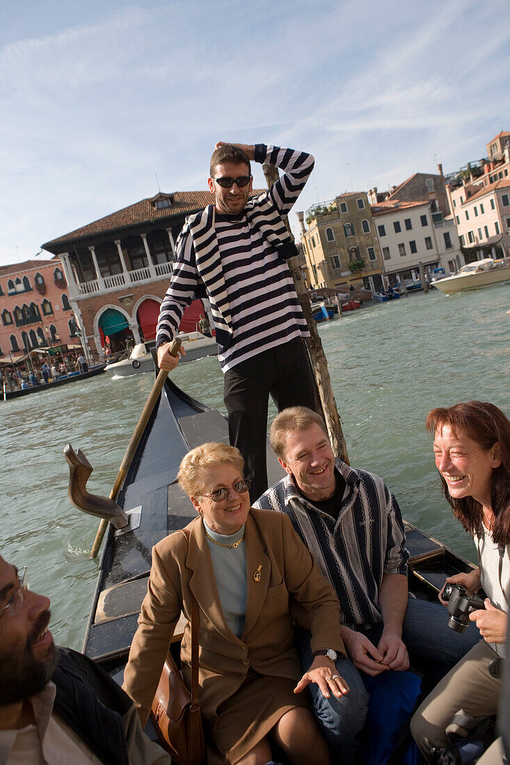 Gondolier on a gondola crossing Grand Canal with passengers, Venice, Veneto, Italy