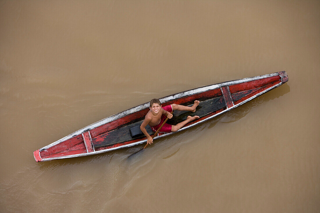 Amazon Indian boy in a canoe on the Amazon River, Rio do Cajari, Para, Brazil, South America