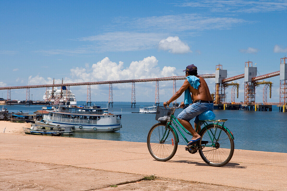 Man cycling along the Amazon River Waterfront, Santarem, Amazon, Brazil, South America