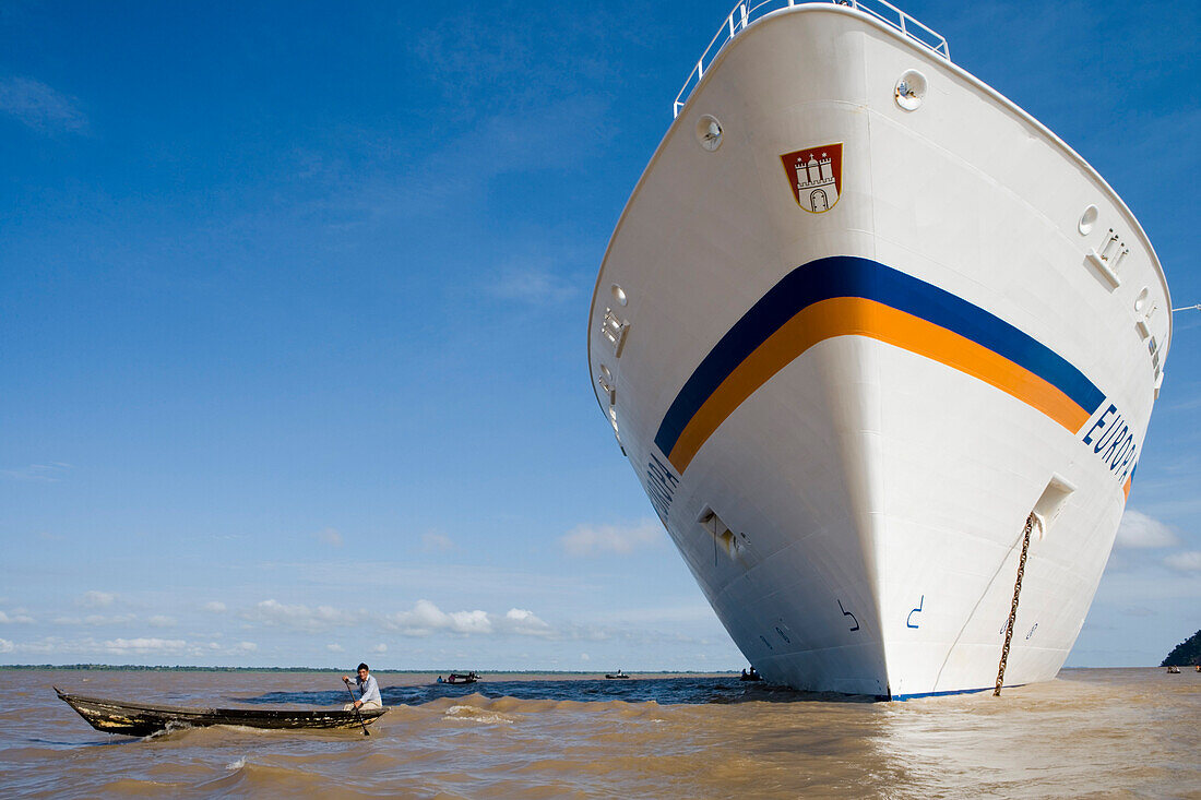 Amazon Indian Man in a canoe and MS Europa on the Amazon River, Boca da Valeria, Amazonas, Brazil