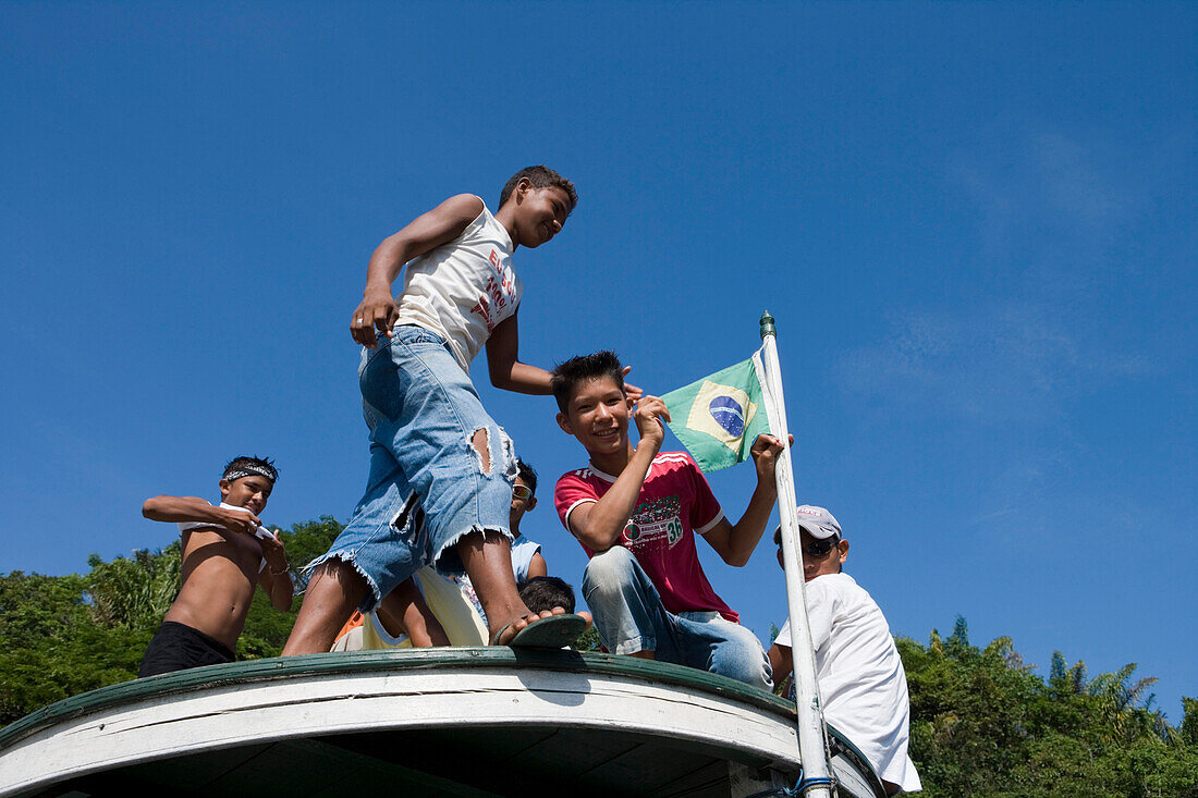 Children on the roof of a boat on a sidearm of the Amazon river, Boca da Valeria, Amazonas, Brazil, South America