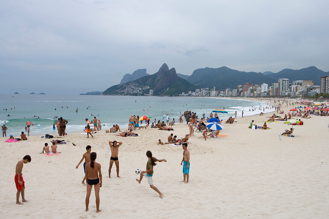 Young men playing beach soccer on Ipanema Beach, Ipanema, Rio de Janeiro, Brazil, South America