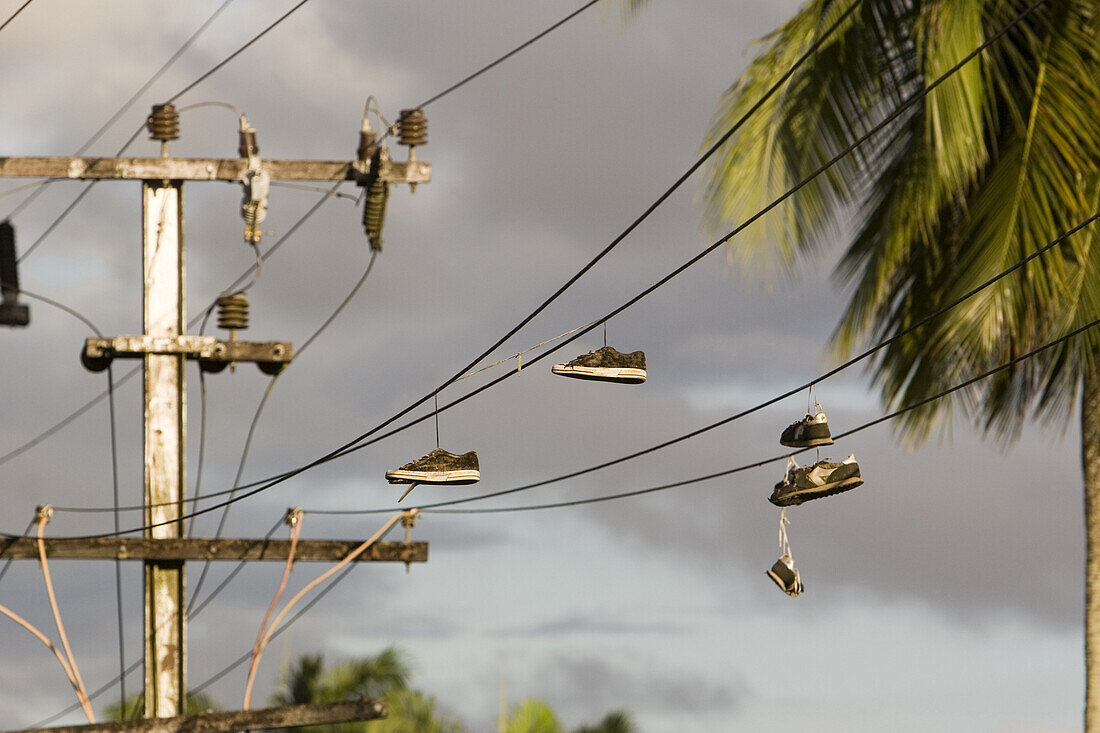 Shoes hanging over electric wire in the evening light, Lae, Papua New Guinea, Oceania