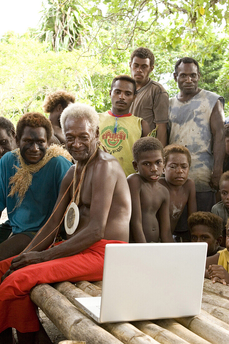Traditional Tribe looking at Apple computer, New Ireland, Papua New Guinea, Oceania