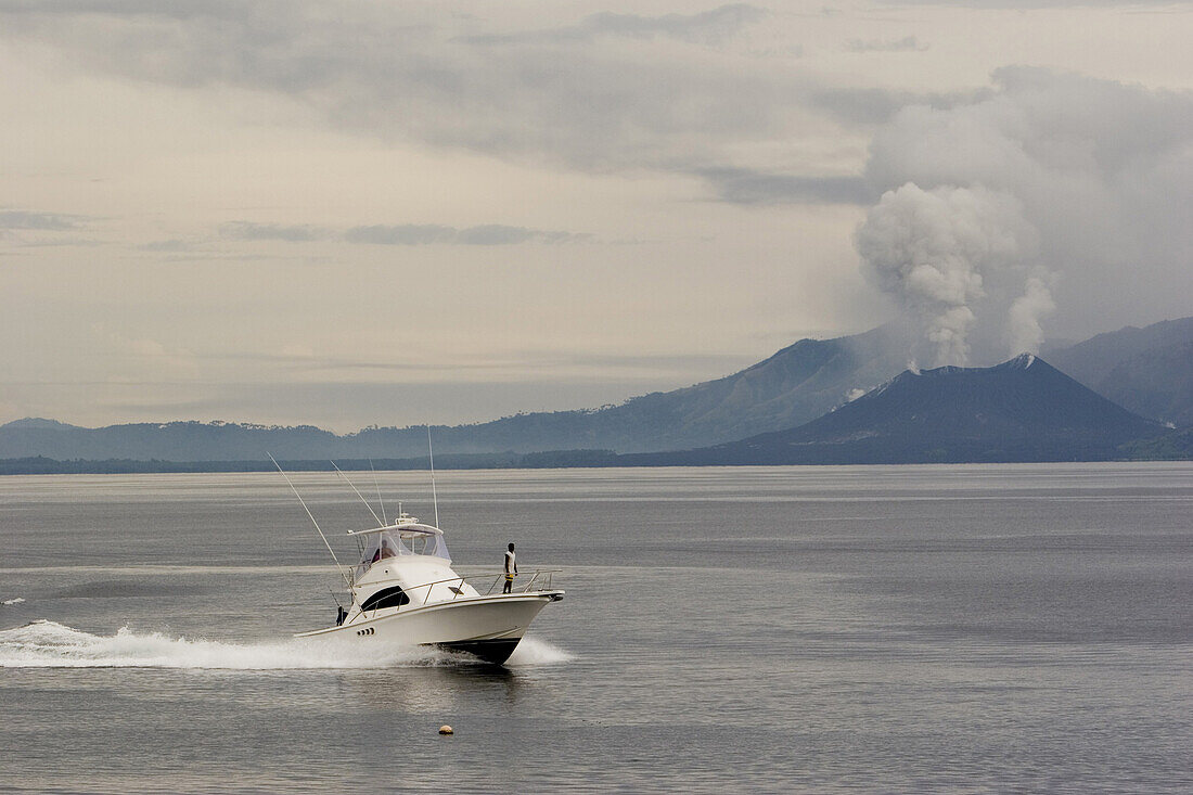 Motorboot vor rauchendem Vulkan, Rabaul, Neubritannien, Papua Neuguinea, Ozeanien