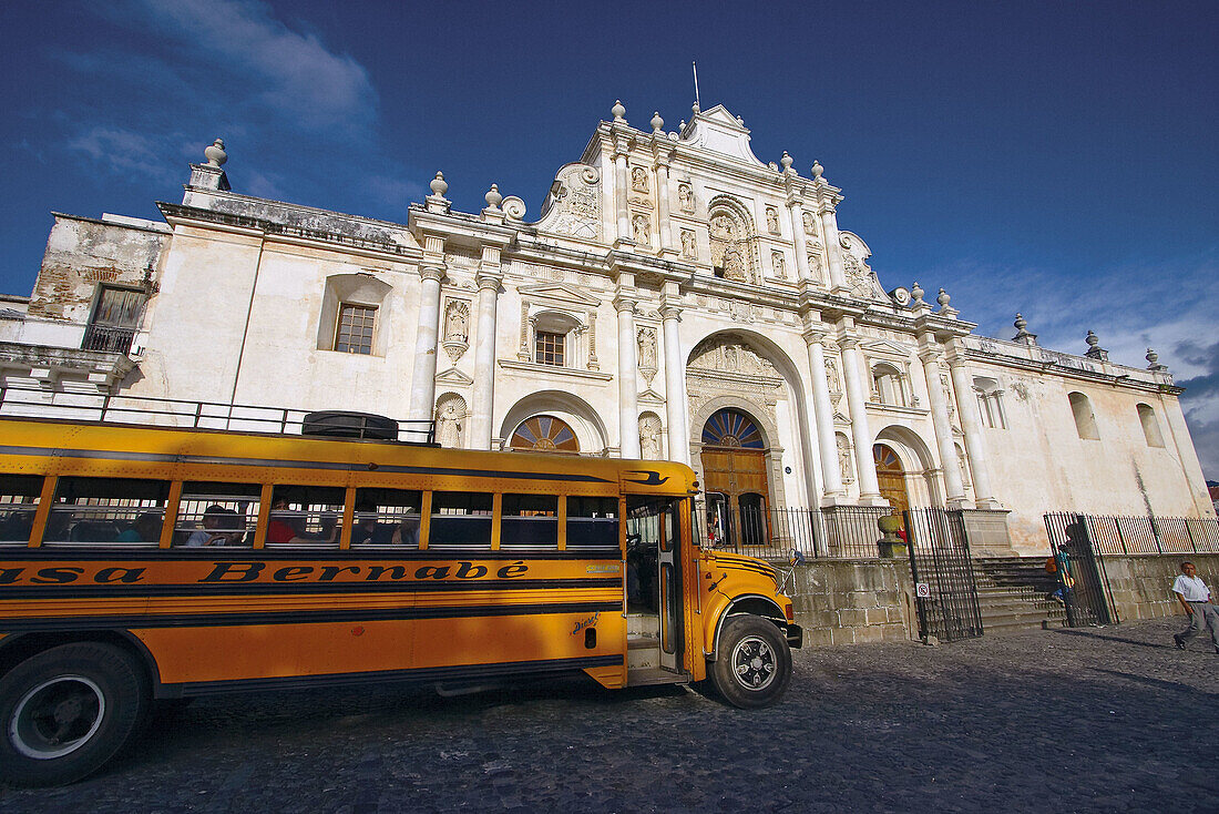 Local bus (formerly american school buses) in front of Santiago s Cathedral. Antigua Guatemala. Sacatepéquez department. Guatemala