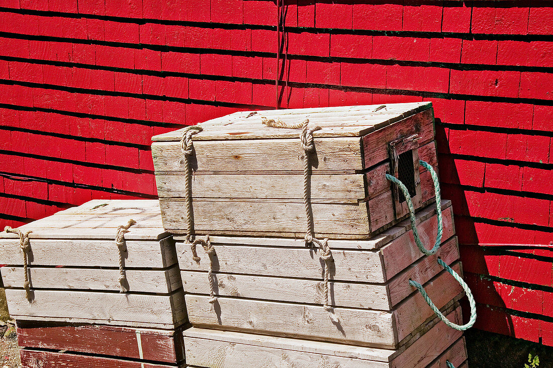 Fishing crates stacked next to red wall of a building, Lunenburg, Canada
