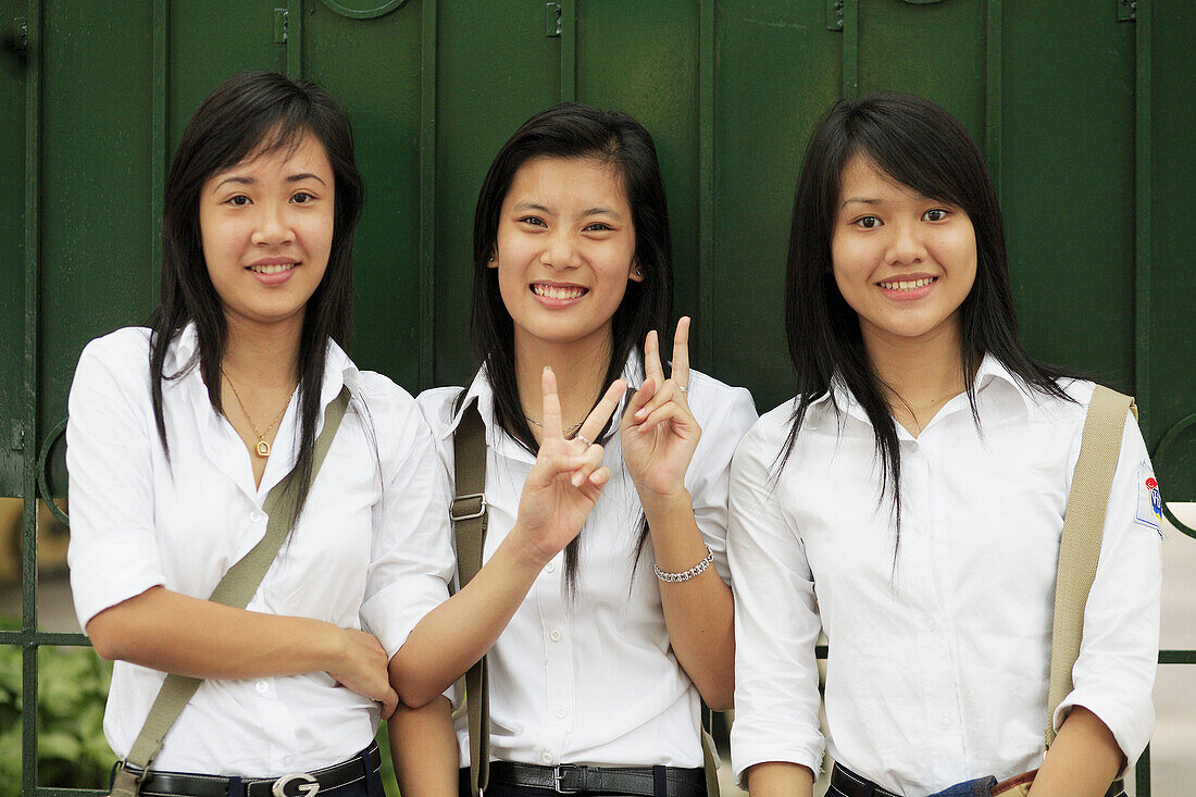 Portrait of teen smiling girls on showing peace sign. The Old Quarter, Hanoi, Vietnam, Indochina, Southeast Asia, Asia 2006