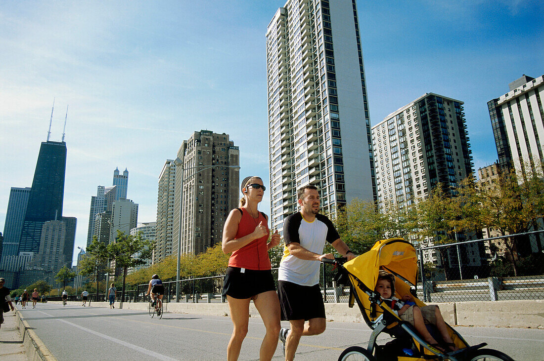 Young family jogging atOak Street Beach, Gold Coast, Chicago, Illinois,USA