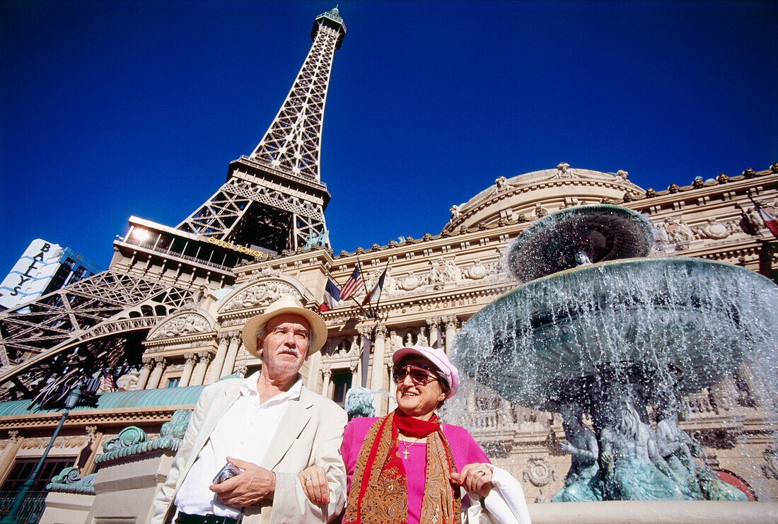 Old couple in front of Hotel and Casino Paris, Las Vegas, Nevada, USA, America