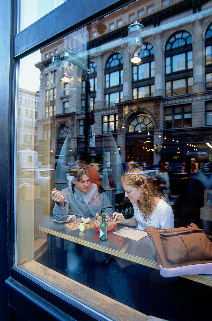 Freunde beim Essen hinter Glasscheibe in Café, 5th Avenue, Manhattan, New York, USA, Amerika