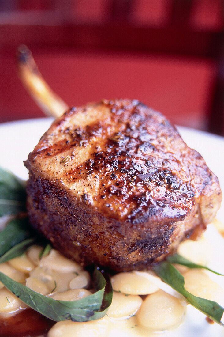 Pork chop with parmesan butter beans and dandelion, Restaurant The Little Owl, Manhattan, New York, USA, America