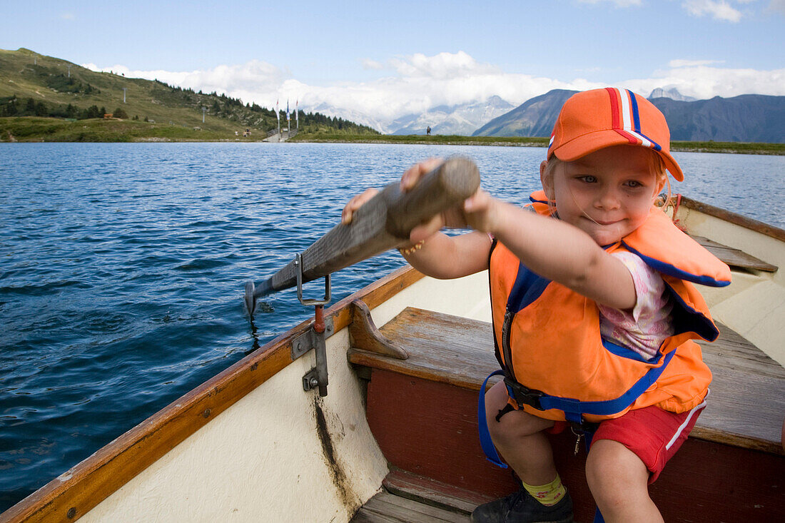 Mädchen (3-4 Jahre) rudert auf dem Bettmersee, Bettmeralp, Kanton Wallis, Schweiz