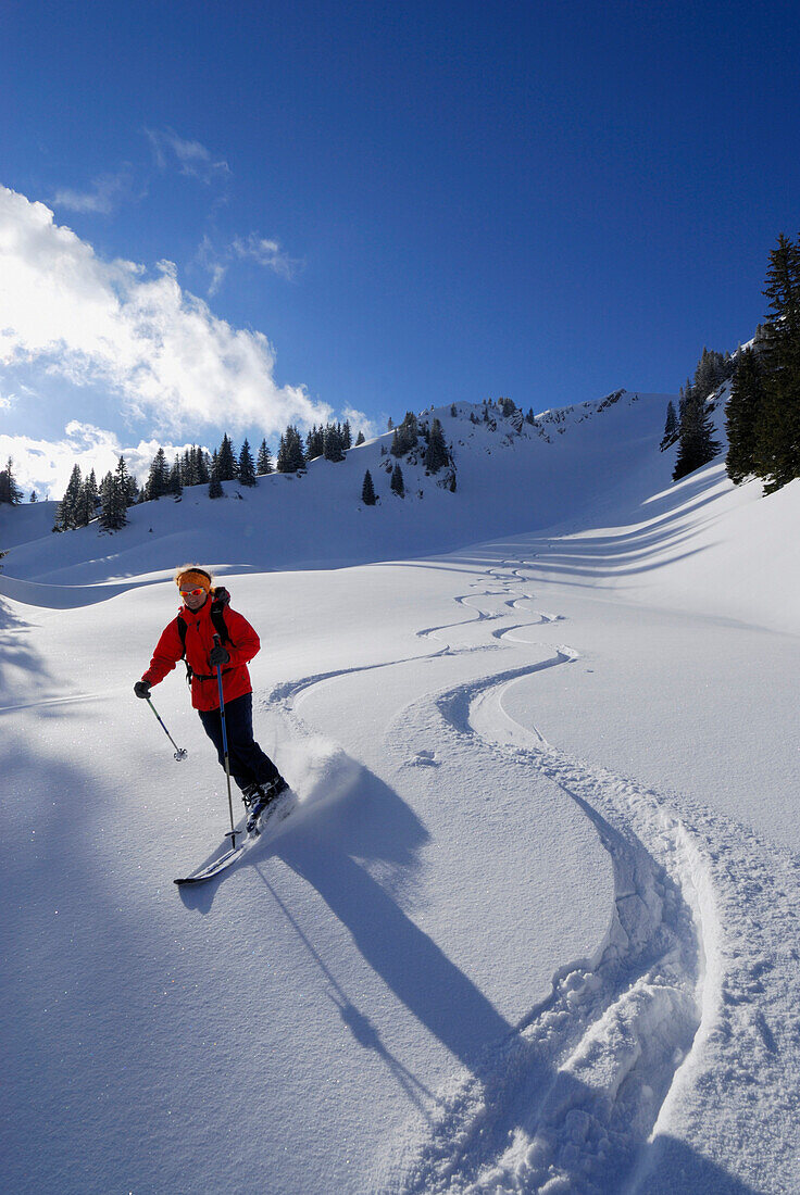 Skifahrerin fährt im Tiefschnee am Rindalphorn, Allgäuer Alpen, Bayern, Deutschland