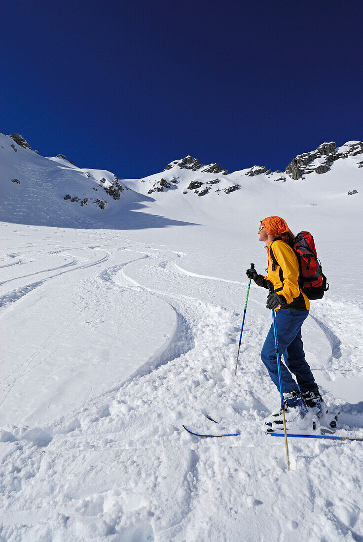 Junge Frau bei Pulverschneeabfahrt, Woleggleskarspitze, Allgäuer Alpen, Allgäu, Tirol, Österreich