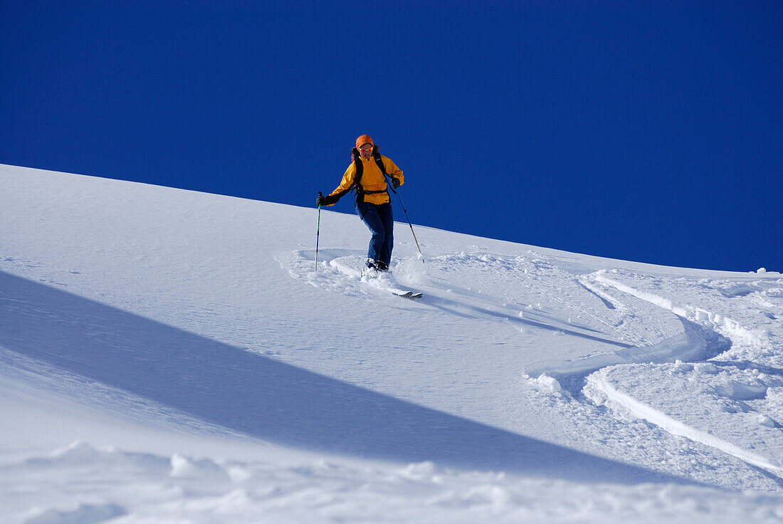 Junge Frau bei Pulverschneeabfahrt, Woleggleskarspitze, Allgäuer Alpen, Allgäu, Tirol, Österreich