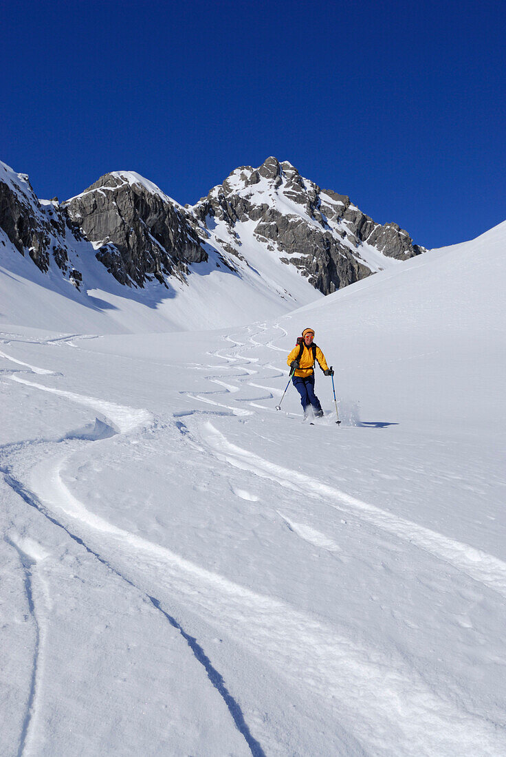 Junge Frau auf Pulverschneeabfahrt im Noppenkar, Allgäuer Alpen, Allgäu, Tirol, Österreich