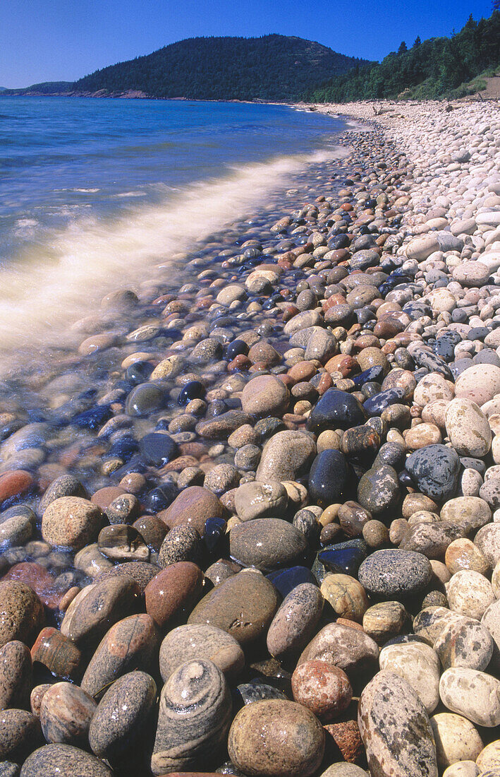 Summer waves crashing along inmense Pebble beach on Lake Superior shoreline. Ontario. Canada