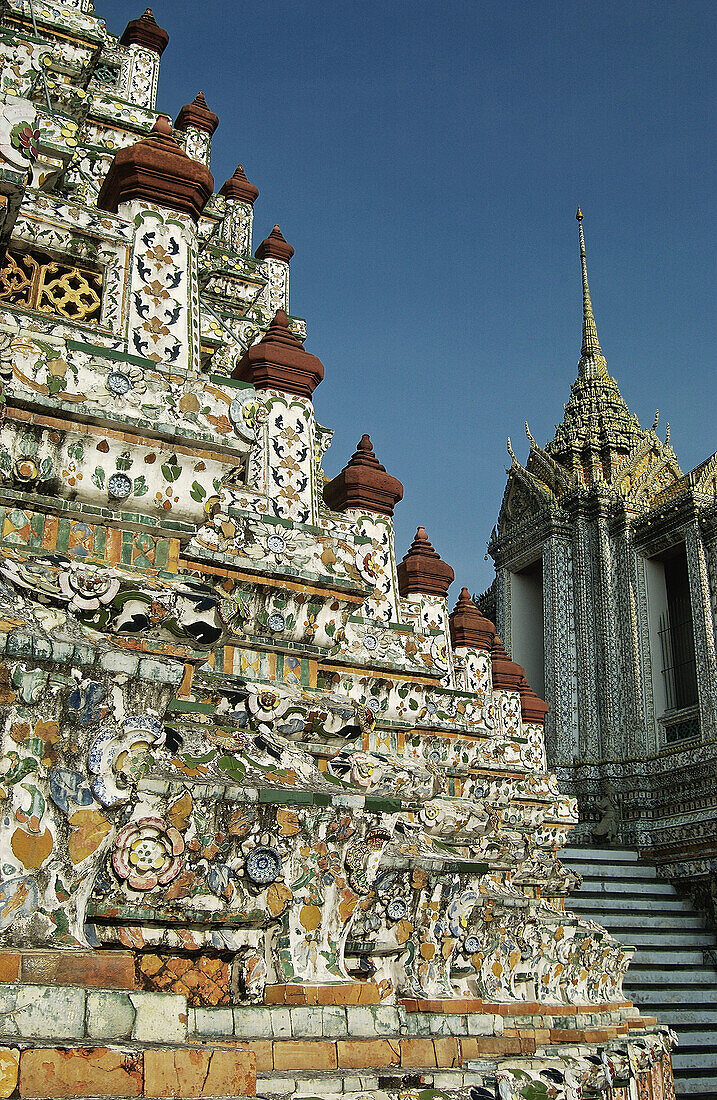 Close up on the tower plated with mosaic of porcelain pieces. Wat Arun temple (Temple of the Dawn). Bangkok. Thailand