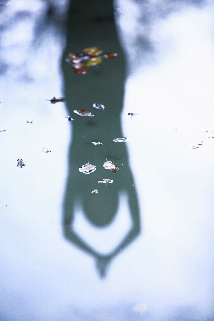 Reflection of a woman practicing yoga on water surface, Allgeau, Germany
