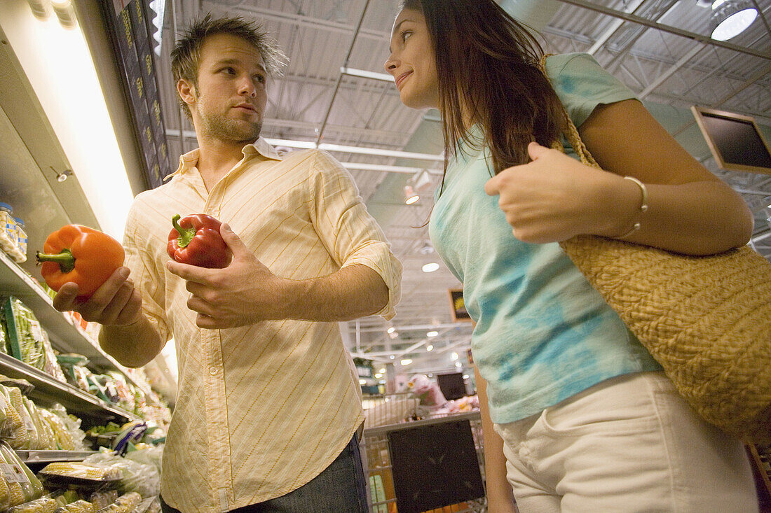 couple shopping for produce in supermarket