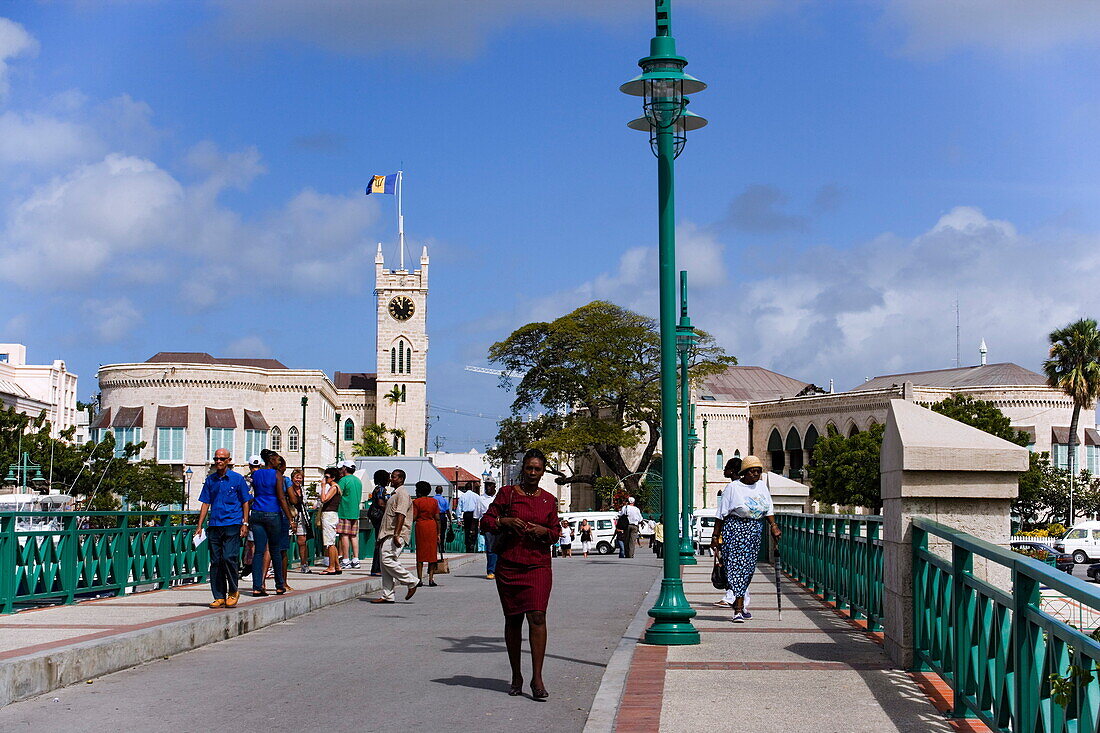 People walking over a bridge, parliament building in background, Bridgetown, Barbados, Caribbean