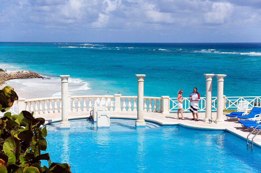 Vacationer at swimming pool of the Crane Hotel, Atlantic Ocean in background, Barbados, Caribbean
