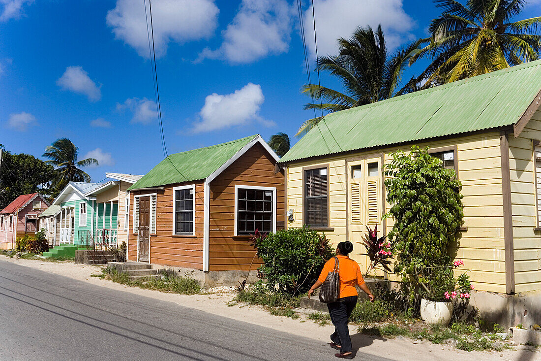 Woman walking along Chattel Houses, Six Men's Bay, Barbados, Caribbean
