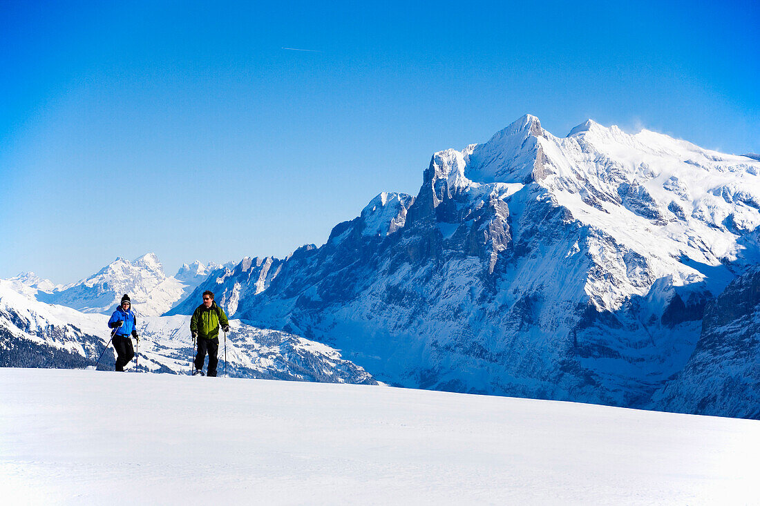 Two persons snowshoeing, Maennlichen, Grindelwald, Bernese Oberland, Canton of Bern, Switzerland