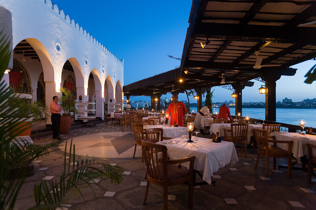 Waiters decorating tables on terrace of the restaurant Tamarind, Mombasa, Kenya